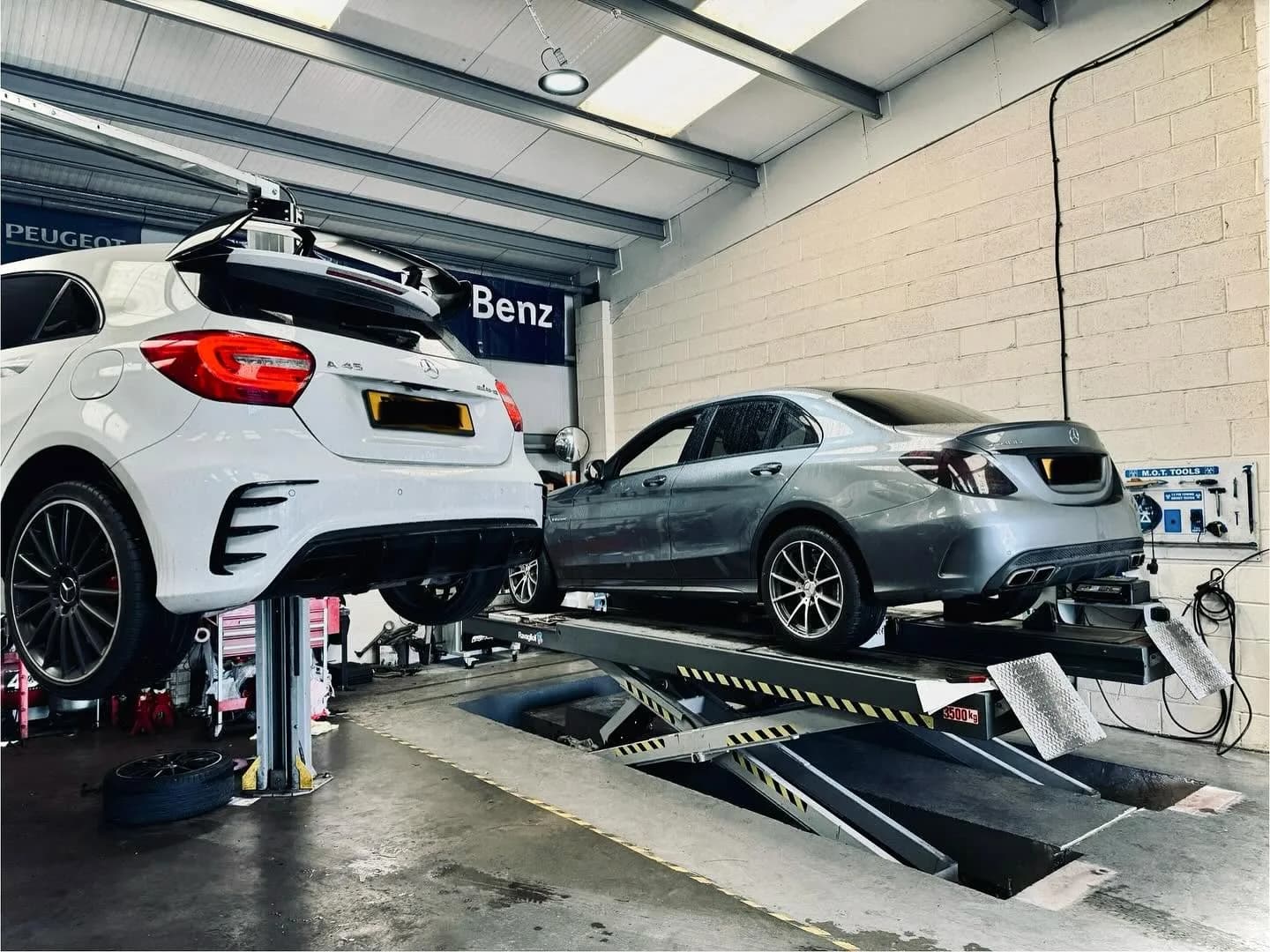 Mercedes-Benz vehicles on lifts inside Benza Autos workshop in Birkenhead